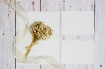 stationary and dried flowers on a white wood background 