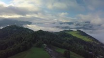 Aerial foggy country landscape in morning light above clouds with beautiful colors at sunrise
