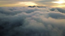 Fly above misty clouds heaven in mountains nature at golden sunrise Aerial view background
