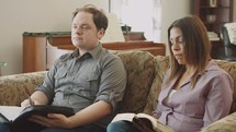 couple sitting on a couch listening to a speaker at a Bible study 