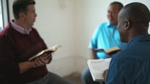 men reading Bibles and discussing scripture 