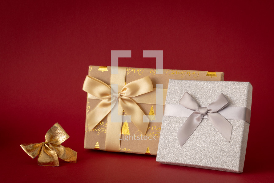 gold and silver wrapped Christmas gifts on a red background 
