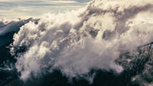 Time lapse of clouds rolling over mountains.