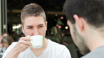 two men in conversation over coffee 