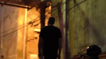 a man walking down a sidewalk alone at night 