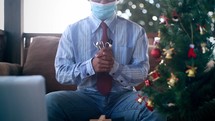 a man holding a stethoscope praying for healthcare workers around a Christmas tree 