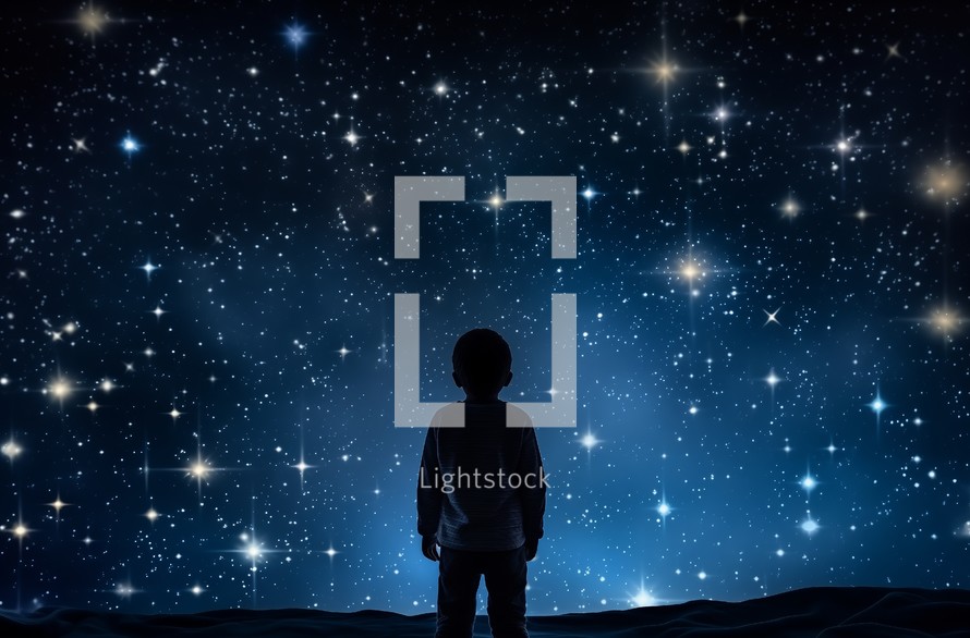 Silhouette of a young child standing and observing the night sky full of stars