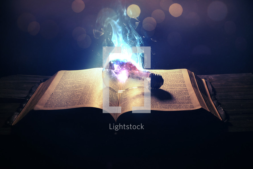 smoking lightbulb on the pages of a Bible 