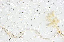 gold confetti, ribbon, and fuzzy grasses 