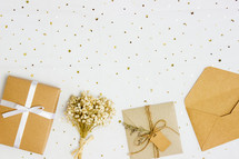 gold confetti, wrapped gift, and dried flowers 