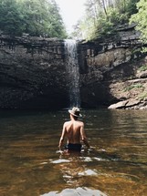 man wading in a water hole 