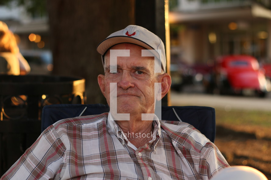 An older man sitting outside.