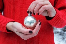 holding a Christmas ornament