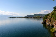 A large lake with clear still water among mountains.
