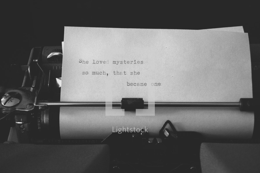 An old manual typewriter with a line of text typed on the paper.