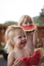 toddler girls eating watermelons 