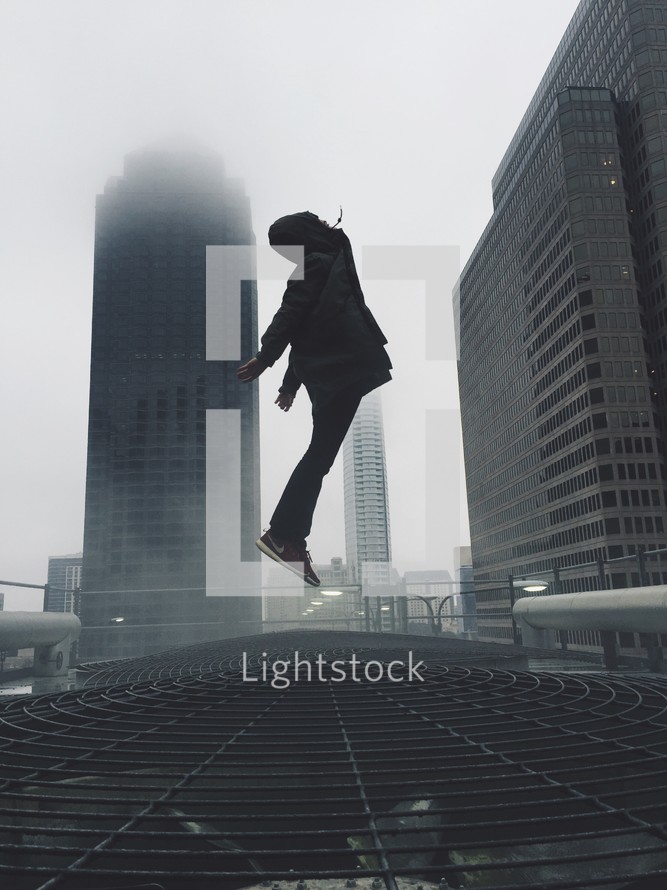 man leaping in a foggy city 