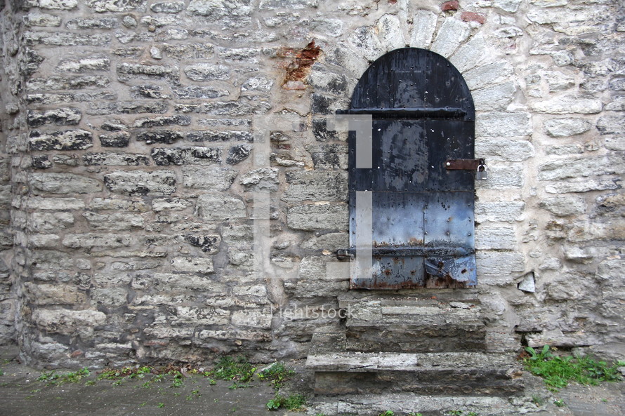 Arched doors in a stone wall doorway