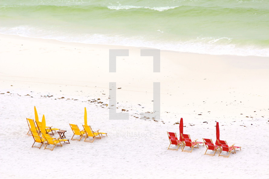 umbrellas on a beach and lounge chairs