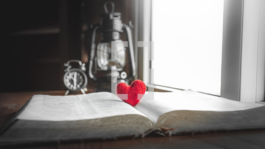 red felt heart on the pages of a Bible 