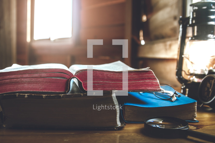 open Bible and magnifying glass on a desk 