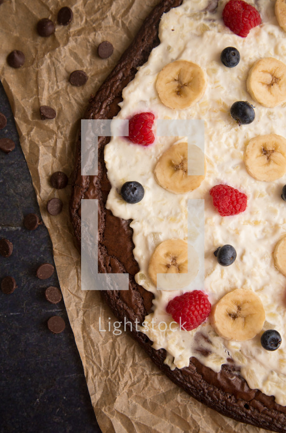 Brownie Dessert Pizza Topped with Fruits and Cream Cheese Frosting