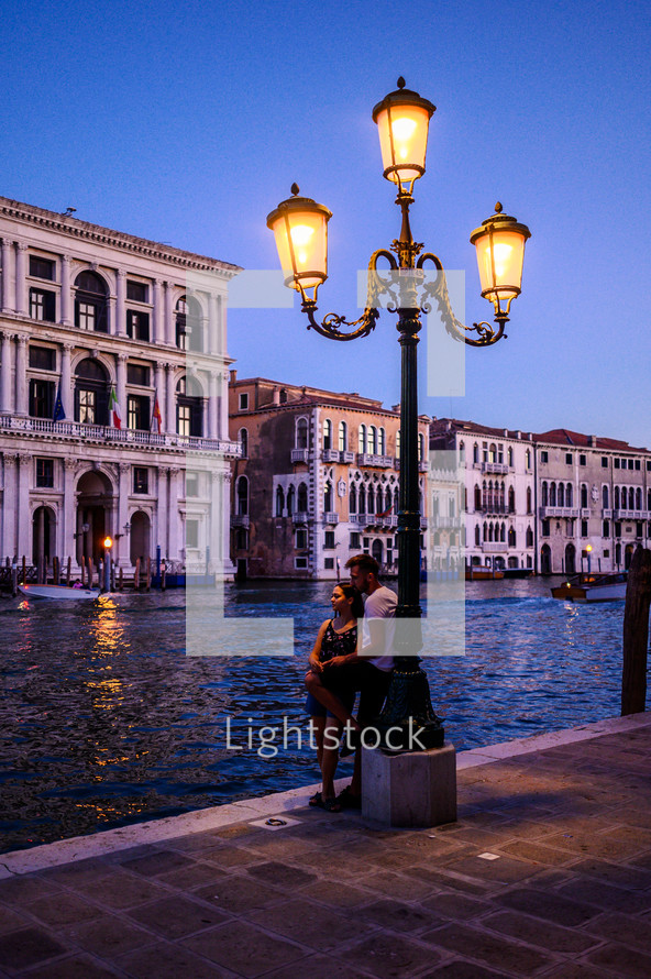 a couple standing under a street lamp in Venice 