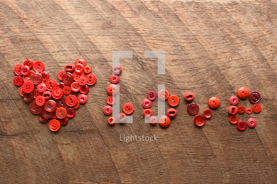 red buttons in the shape of a heart and word love 