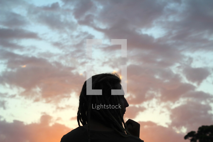 silhouette of a man with dreads at dusk 