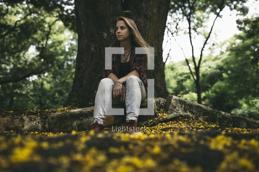 teen girl sitting under a tree 