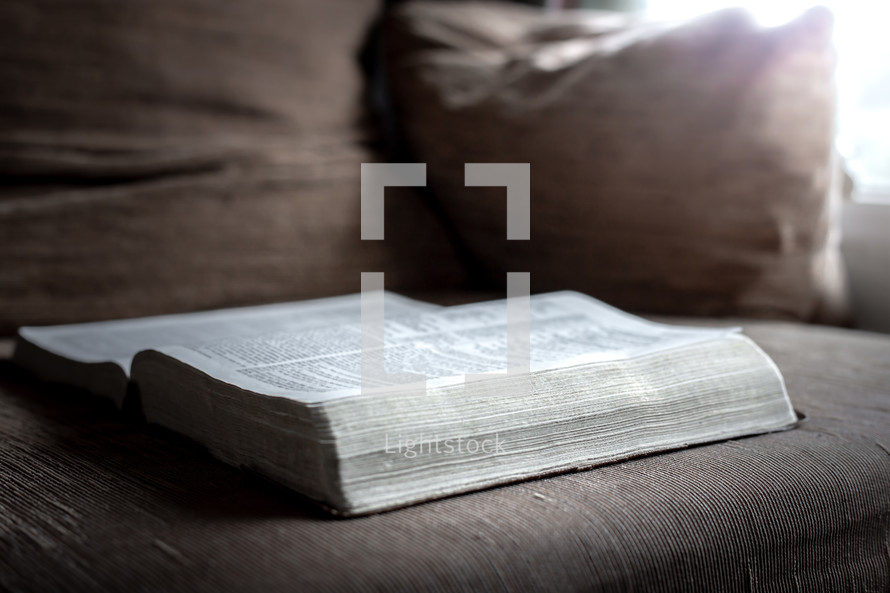 open Bible on a couch 