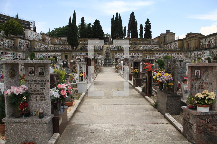 flowers and photos on grave markers in a cemetery 