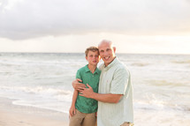 father and son hugging on a beach 