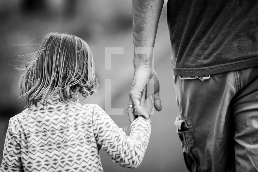 a man and his daughter holding hands 