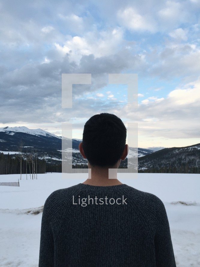 man looking out at white snow 