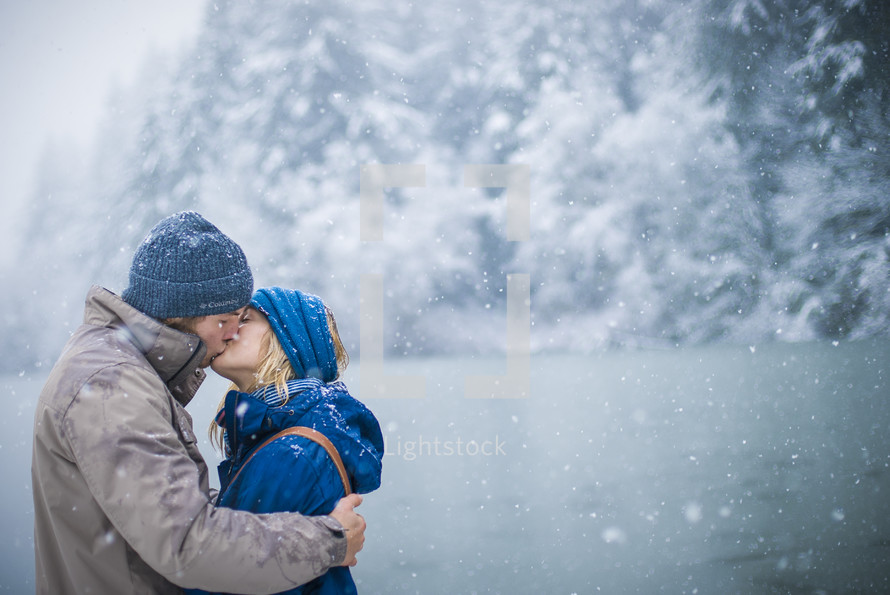 a couple kissing in the snow 