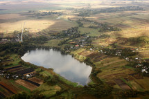 view of the village from the sky. photo with noise. Aerial view of farmland area landscape and lake from airplane. Landscape with lake. Environment protection. Drone flight
