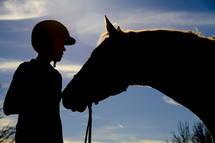 Silhouette of a boy with his horse.