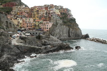 Village of homes on cliffside overlooking ocean.