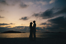 silhouette of a bride and groom on a beach 