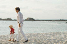 father and son walking on a beach 