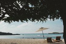 lounge chairs and beach umbrella on a beach 