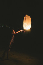 woman releasing a paper lantern 