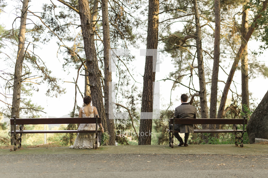 bride and groom sitting on benches 