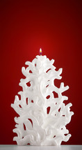 Christmas candle shaped like a Christmas tree on red background