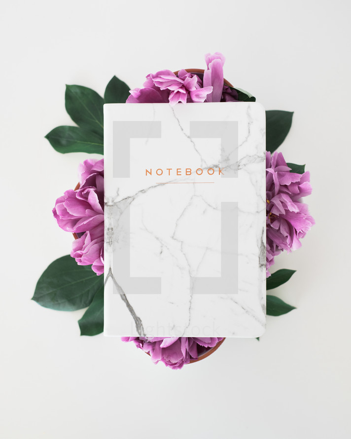 notebook on a cup of purple flowers 