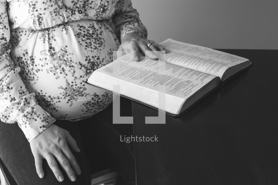 a pregnant woman reading a Bible 