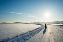 traveling down a snow covered dirt road in winter 