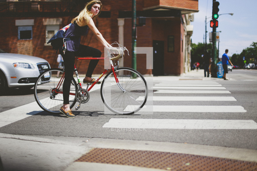 woman riding a bicycle on a downtown street 