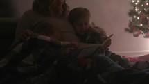 a mother reading to her children at Christmas 